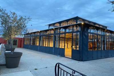 Salle de réception lumineuse avec des invités assis à des tables rondes sous un éclairage violet.