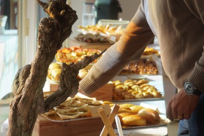 Salle de réception lumineuse avec des invités assis à des tables rondes sous un éclairage violet.