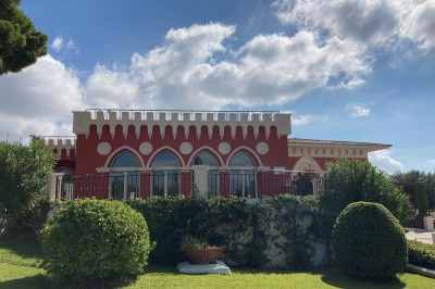 Salle de réception lumineuse avec des invités assis à des tables rondes sous un éclairage violet.