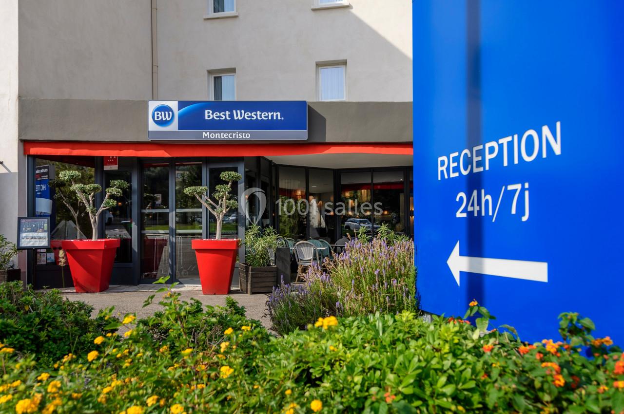 Façade d'un hôtel Best Western avec entrée principale, plantes en pot et panneau indiquant une réception ouverte 24h/7j.