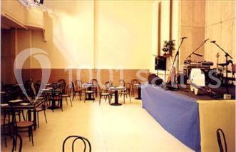 Salle avec des tables et des chaises disposées devant une scène équipée d'instruments de musique.