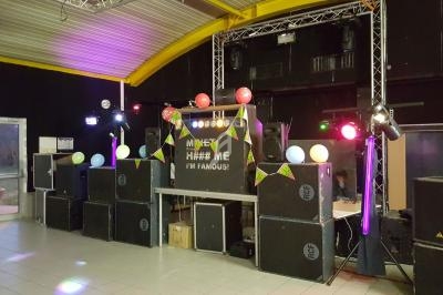 Installation de matériel de sonorisation et éclairage coloré dans une salle pour un événement festif.