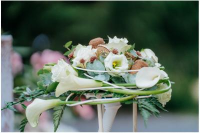Terrasse extérieure d'un restaurant avec des tables et chaises sur un sol en pierre, entourée de verdure et arbres.
