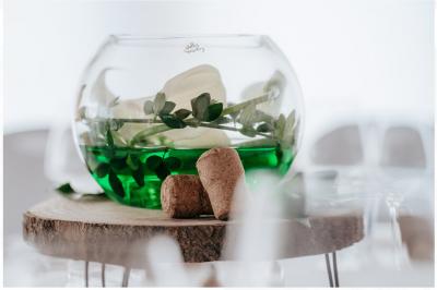 Terrasse extérieure d'un restaurant avec des tables et chaises sur un sol en pierre, entourée de verdure et arbres.