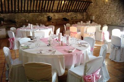 Groupe de personnes rassemblées dans une cour extérieure verdoyante devant un bâtiment en pierre avec des volets bleus.