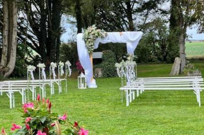Salle de réception décorée avec des tables dressées, des guirlandes lumineuses et des arrangements floraux.