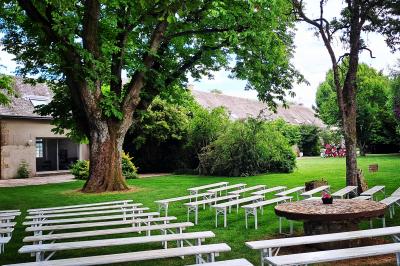Salle de réception décorée avec des tables dressées, des guirlandes lumineuses et des arrangements floraux.