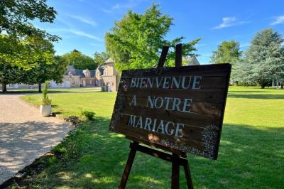 Salle de réception décorée avec des tables dressées, des guirlandes lumineuses et des arrangements floraux.