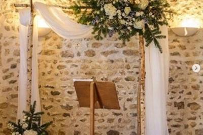 Salle de réception décorée avec des tables dressées, des guirlandes lumineuses et des arrangements floraux.