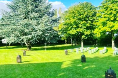 Salle de réception décorée avec des tables dressées, des guirlandes lumineuses et des arrangements floraux.