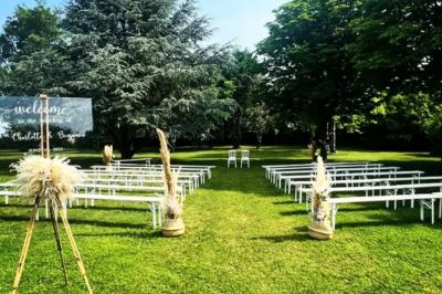 Salle de réception décorée avec des tables dressées, des guirlandes lumineuses et des arrangements floraux.