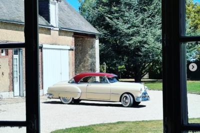Salle de réception décorée avec des tables dressées, des guirlandes lumineuses et des arrangements floraux.