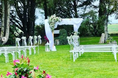 Salle de réception décorée avec des tables dressées, des guirlandes lumineuses et des arrangements floraux.