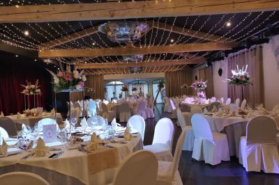 Un groupe de musiciens joue sur une petite scène extérieure sous un ciel bleu, entouré de décorations en bois.