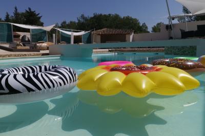 Un groupe de musiciens joue sur une petite scène extérieure sous un ciel bleu, entouré de décorations en bois.