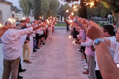 Un groupe de musiciens joue sur une petite scène extérieure sous un ciel bleu, entouré de décorations en bois.