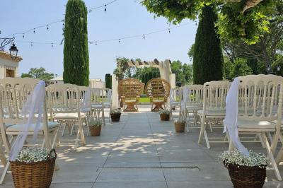 Un groupe de musiciens joue sur une petite scène extérieure sous un ciel bleu, entouré de décorations en bois.