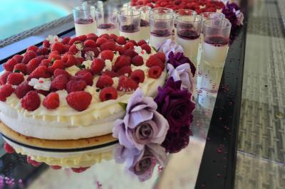 Un groupe de musiciens joue sur une petite scène extérieure sous un ciel bleu, entouré de décorations en bois.