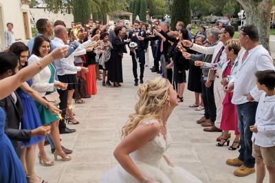 Un groupe de musiciens joue sur une petite scène extérieure sous un ciel bleu, entouré de décorations en bois.