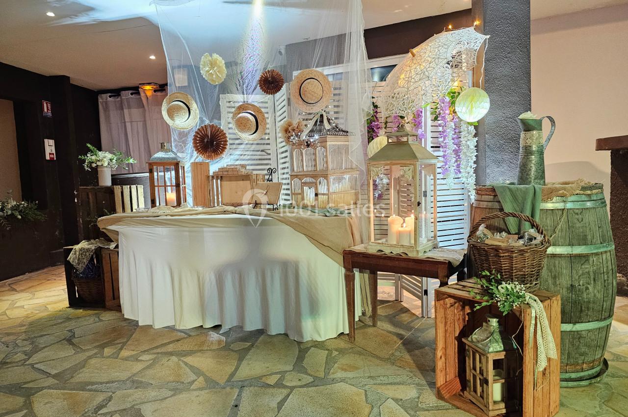 Décoration rustique avec lanternes, paniers, tonneau et éléments champêtres sur une table et autour, ambiance chaleureuse.