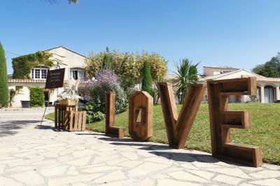 Un groupe de musiciens joue sur une petite scène extérieure sous un ciel bleu, entouré de décorations en bois.