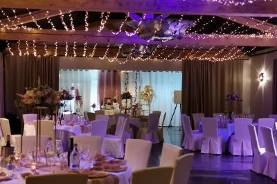 Un groupe de musiciens joue sur une petite scène extérieure sous un ciel bleu, entouré de décorations en bois.
