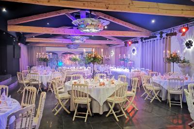 Un groupe de musiciens joue sur une petite scène extérieure sous un ciel bleu, entouré de décorations en bois.