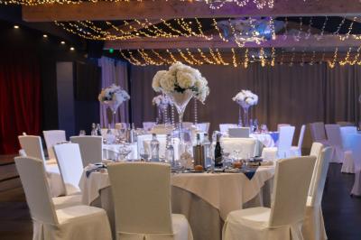 Un groupe de musiciens joue sur une petite scène extérieure sous un ciel bleu, entouré de décorations en bois.