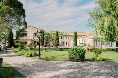 Un groupe de musiciens joue sur une petite scène extérieure sous un ciel bleu, entouré de décorations en bois.
