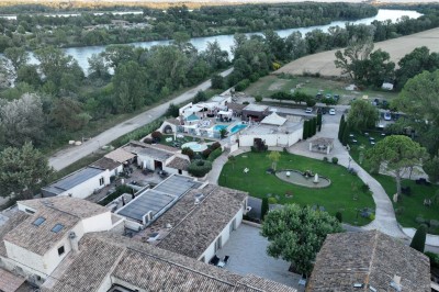 Un groupe de musiciens joue sur une petite scène extérieure sous un ciel bleu, entouré de décorations en bois.