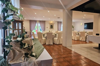 Un groupe de musiciens joue sur une petite scène extérieure sous un ciel bleu, entouré de décorations en bois.