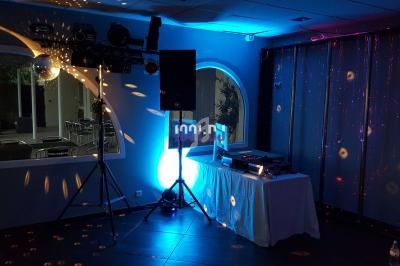 Installation de matériel de sonorisation et éclairage dans une salle avec table de mixage et projecteurs lumineux.