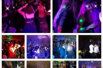 Personnes dansant et discutant lors d'une fête en soirée, éclairée par des lumières colorées et décorée de ballons.