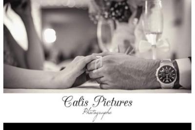 Deux mains se tenant sur une table, avec des verres et une ambiance romantique en arrière-plan.