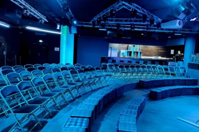 Tunnel d'aquarium avec un grand bassin à droite, éclairages colorés et écran lumineux sur le mur gauche.