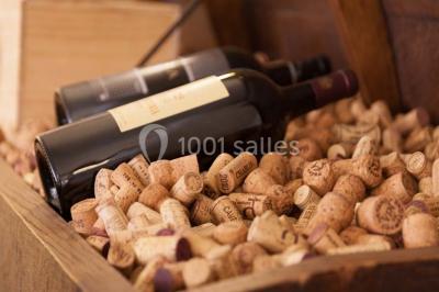 Table dressée avec des verres, couverts et serviettes, entourée de chaises colorées dans une salle lumineuse avec…