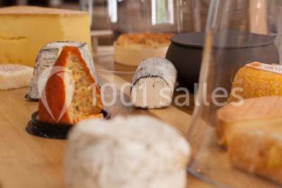 Table dressée avec des verres, couverts et serviettes, entourée de chaises colorées dans une salle lumineuse avec…