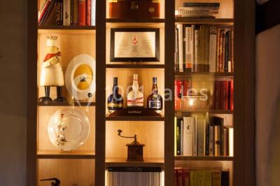 Table dressée avec des verres, couverts et serviettes, entourée de chaises colorées dans une salle lumineuse avec…