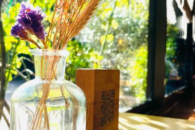 Table dressée avec des verres, couverts et serviettes, entourée de chaises colorées dans une salle lumineuse avec…
