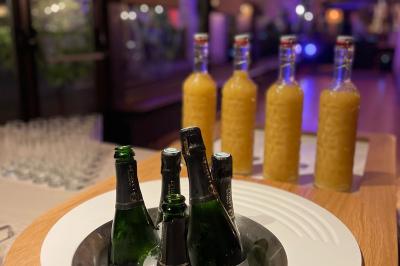 Table dressée avec des verres, couverts et serviettes, entourée de chaises colorées dans une salle lumineuse avec…