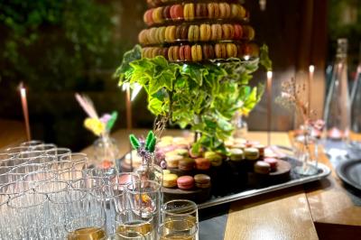 Table dressée avec des verres, couverts et serviettes, entourée de chaises colorées dans une salle lumineuse avec…