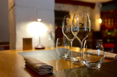 Table dressée avec des verres, couverts et serviettes, entourée de chaises colorées dans une salle lumineuse avec…