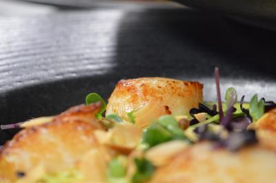 Table dressée avec des verres, couverts et serviettes, entourée de chaises colorées dans une salle lumineuse avec…