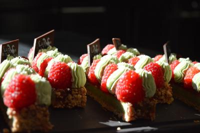 Table dressée avec des verres, couverts et serviettes, entourée de chaises colorées dans une salle lumineuse avec…