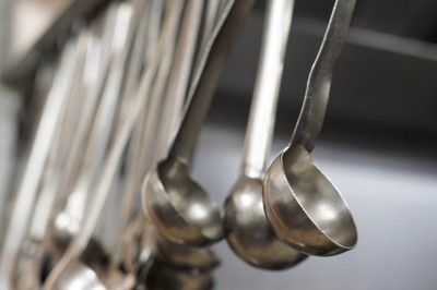 Table dressée avec des verres, couverts et serviettes, entourée de chaises colorées dans une salle lumineuse avec…