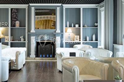 Vue aérienne d'un bâtiment en bord de mer entouré de champs et de vignobles sous un ciel dégagé.