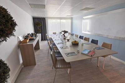 Vue aérienne d'un bâtiment en bord de mer entouré de champs et de vignobles sous un ciel dégagé.