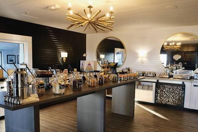 Vue aérienne d'un bâtiment en bord de mer entouré de champs et de vignobles sous un ciel dégagé.