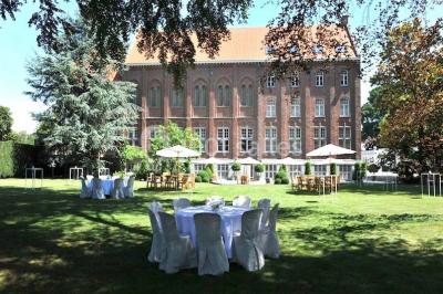 Salle de réception lumineuse avec bar central circulaire, tables hautes et éclairage coloré.