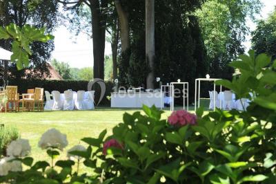 Salle de réception lumineuse avec bar central circulaire, tables hautes et éclairage coloré.